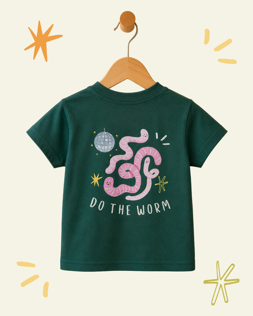 A dark green short-sleeve kids' graphic t-shirt hanging on a wooden hanger against a cream background with decorative doodles. The shirt features a playful graphic of a pink worm with a disco ball and stars, and the text 'DO THE WORM'.