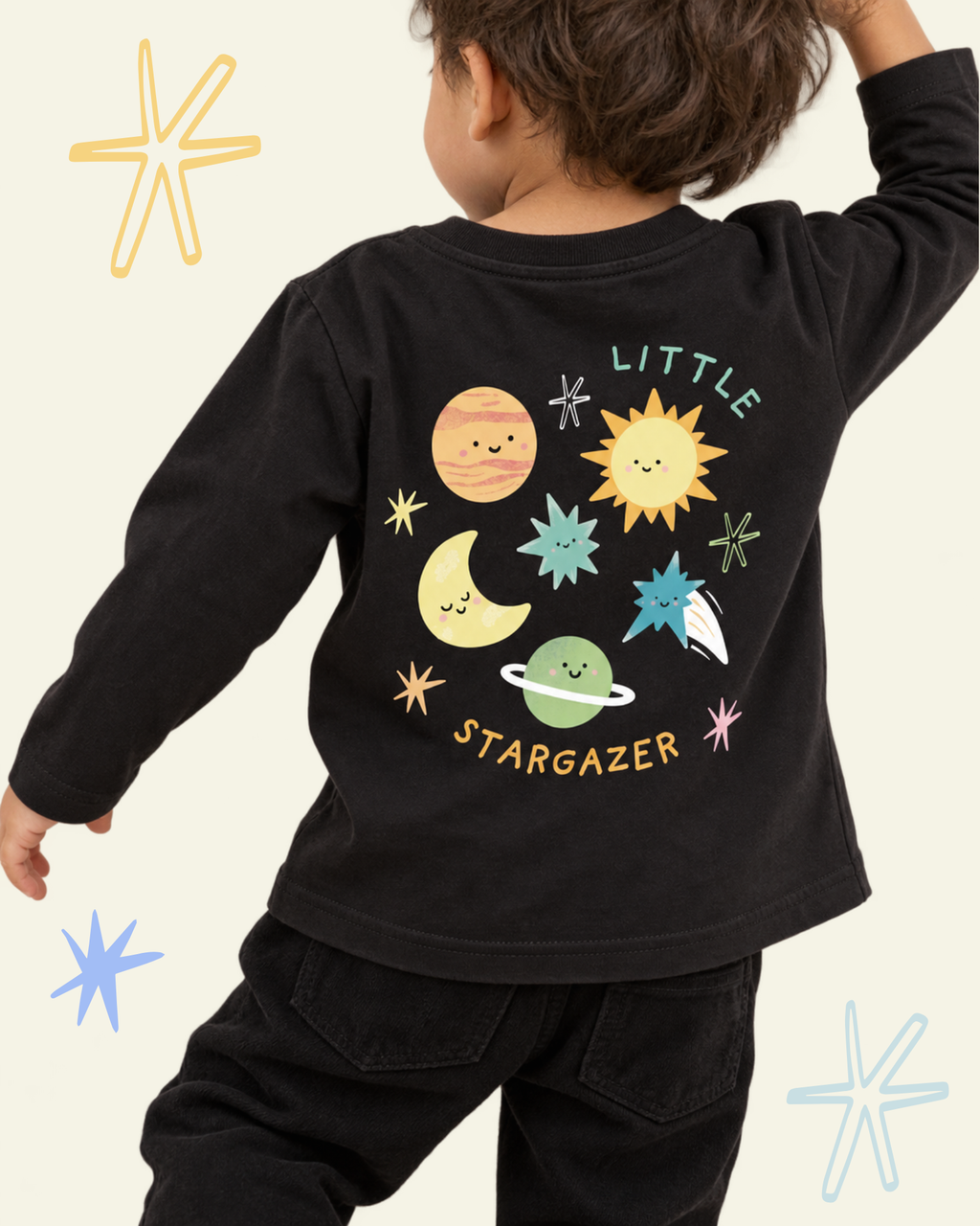 Child wearing a black Stargazer long sleeve T-shirt with colourful planets, sun, moon and stars on the back.