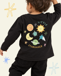 Child wearing a black Stargazer long sleeve T-shirt with colourful planets, sun, moon and stars on the back.